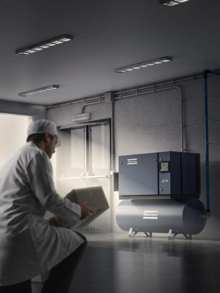 Technician reviewing an Atlas Copco LZ 10 air compressor